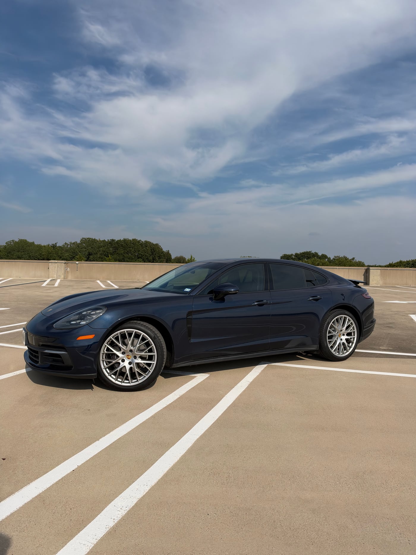 Deep-blue Porsche Panamera available for rental and chauffeur service in Dallas
