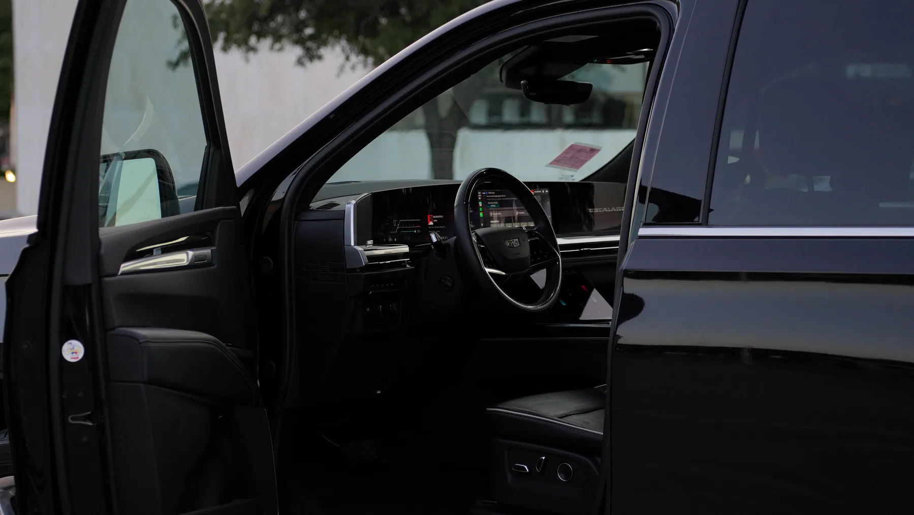 Open Cadillac Escalade cabin with black luxury seating and passenger displays